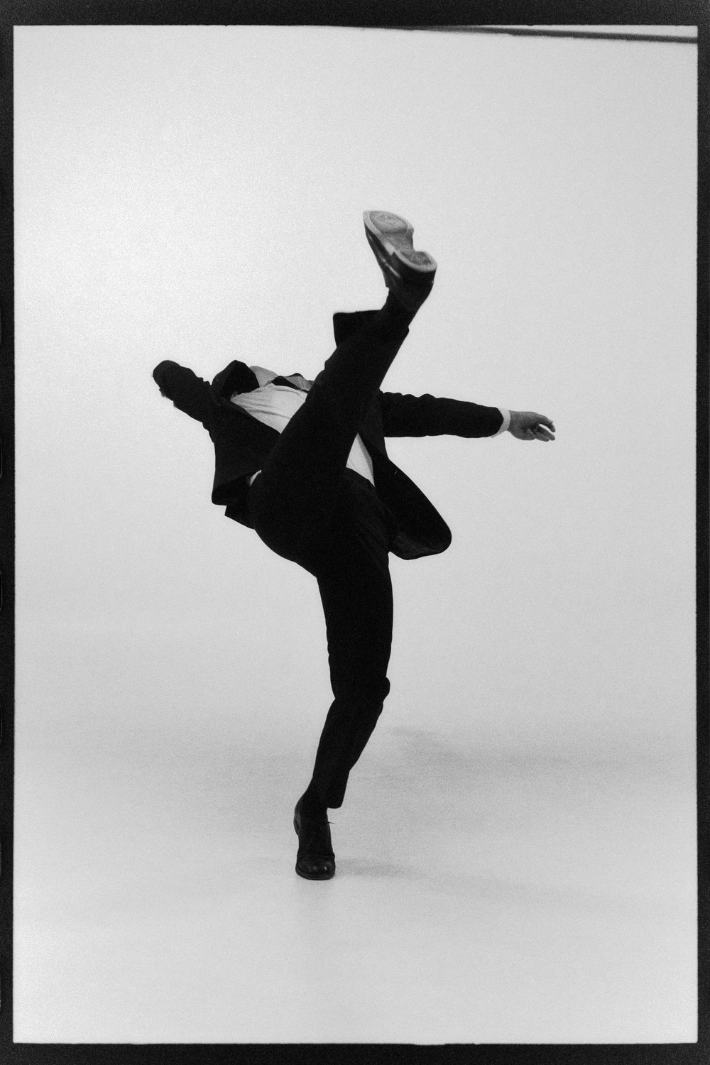 Dancer balancing on one leg with the other kicked high