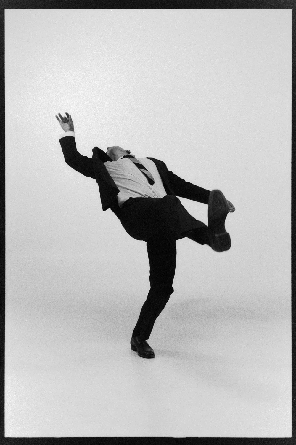 Dancer tipping sideways on one foot, arms thrown out
