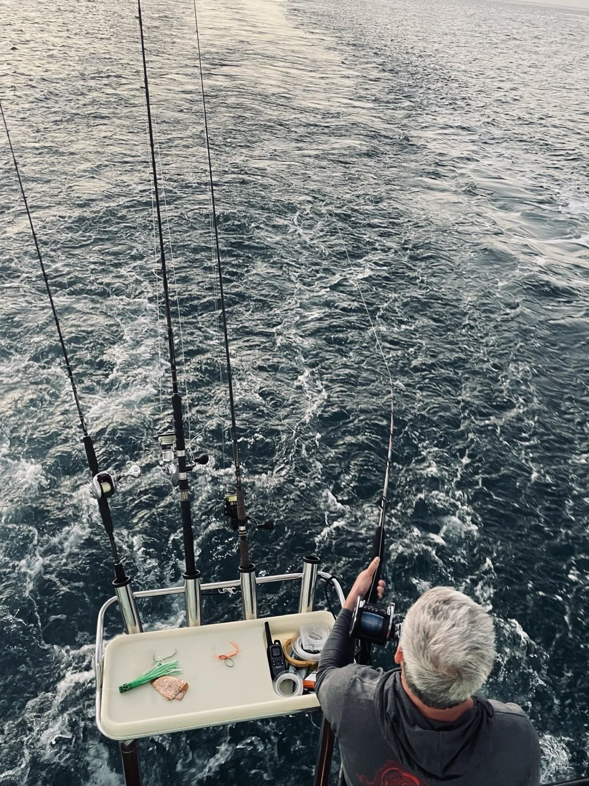 Nathan fishing from a boat in New Zealand, seen from above