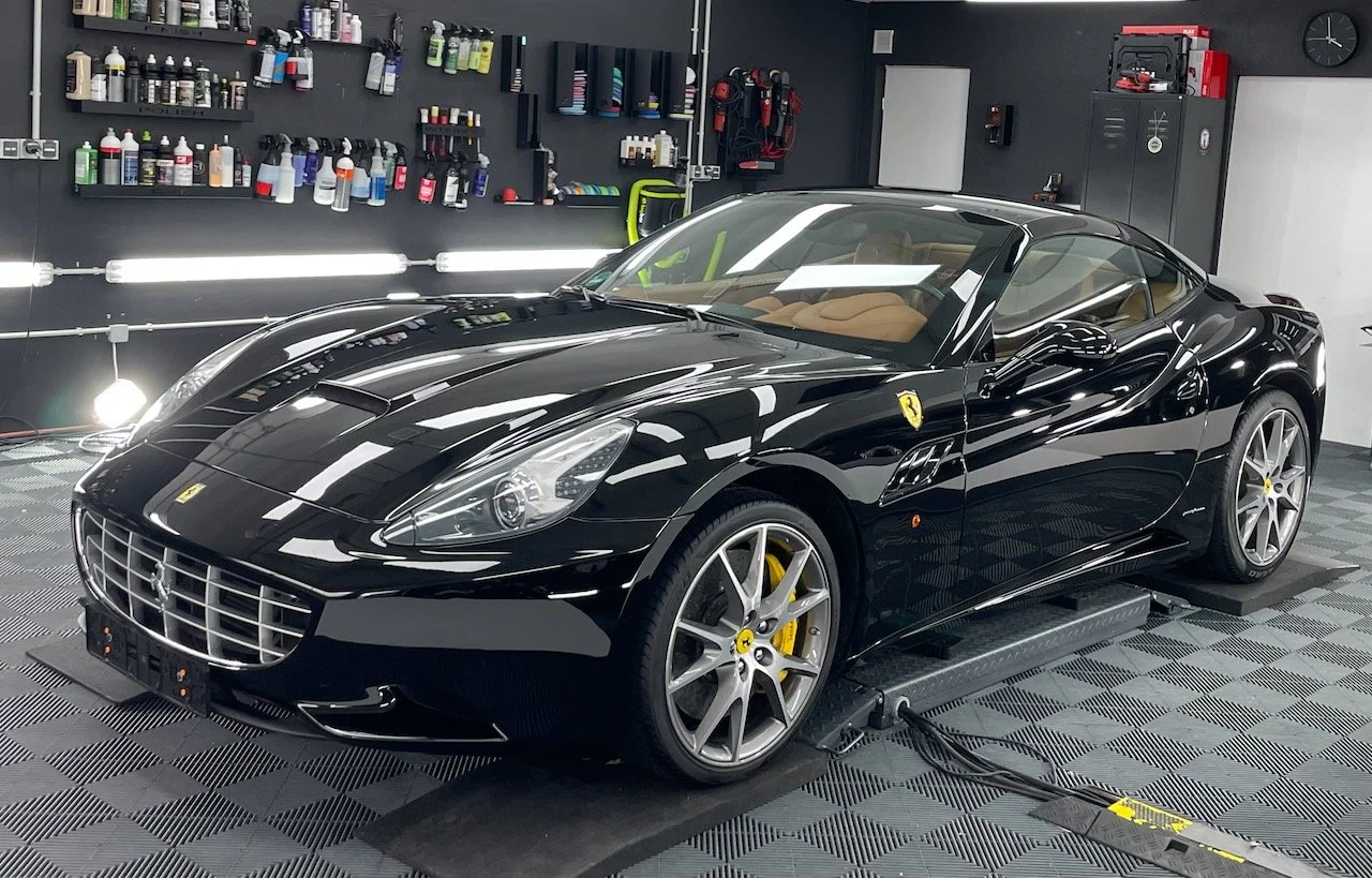 Ferrari California Uni-Schwarz nach Lackkorrektur und Keramikversiegelung in seitlich-frontaler Ansicht