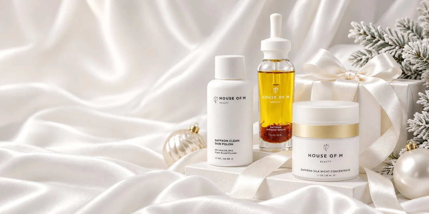 Luxury Christmas skincare campaign photography for House of M Beauty: saffron serum and bottles on white satin with pearl ornaments and frosted pine, Los Angeles