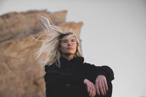 Blonde model with windswept hair in a Women of the Galaxy hoodie, editorial portrait at Vasquez Rocks