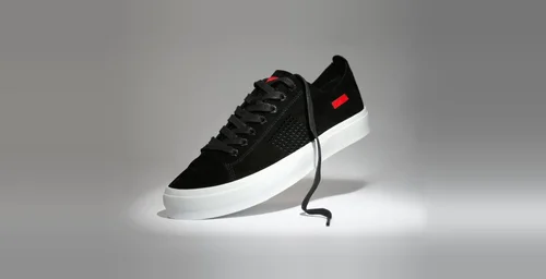 Savalé black suede skate shoe with white sole under a studio spotlight, footwear product photography for a sneaker launch