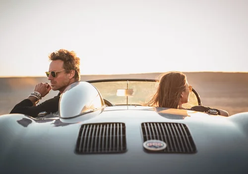 Buck Palmer and a female model in a classic Porsche convertible at golden hour for a Los Angeles men's jewelry campaign