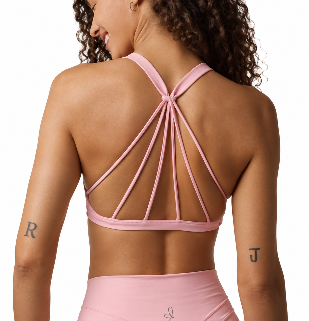 On-model activewear e-commerce photography of a pink strappy sports bra and leggings set, back view, Los Angeles studio