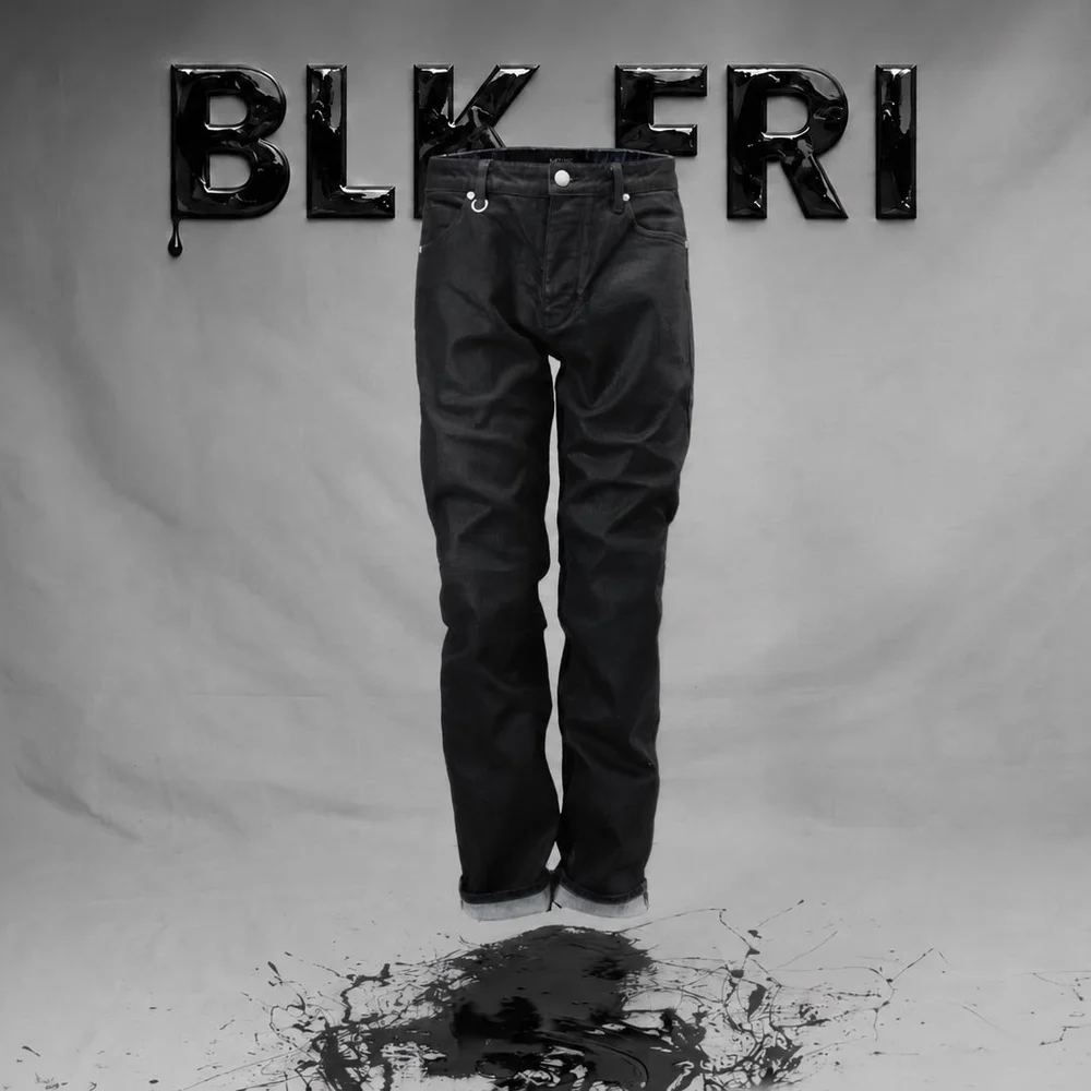Full-length black denim jeans photographed front-on for a Black Friday apparel campaign against a neutral gray studio backdrop, using controlled soft light to preserve fabric texture and separation in the dark tones.
