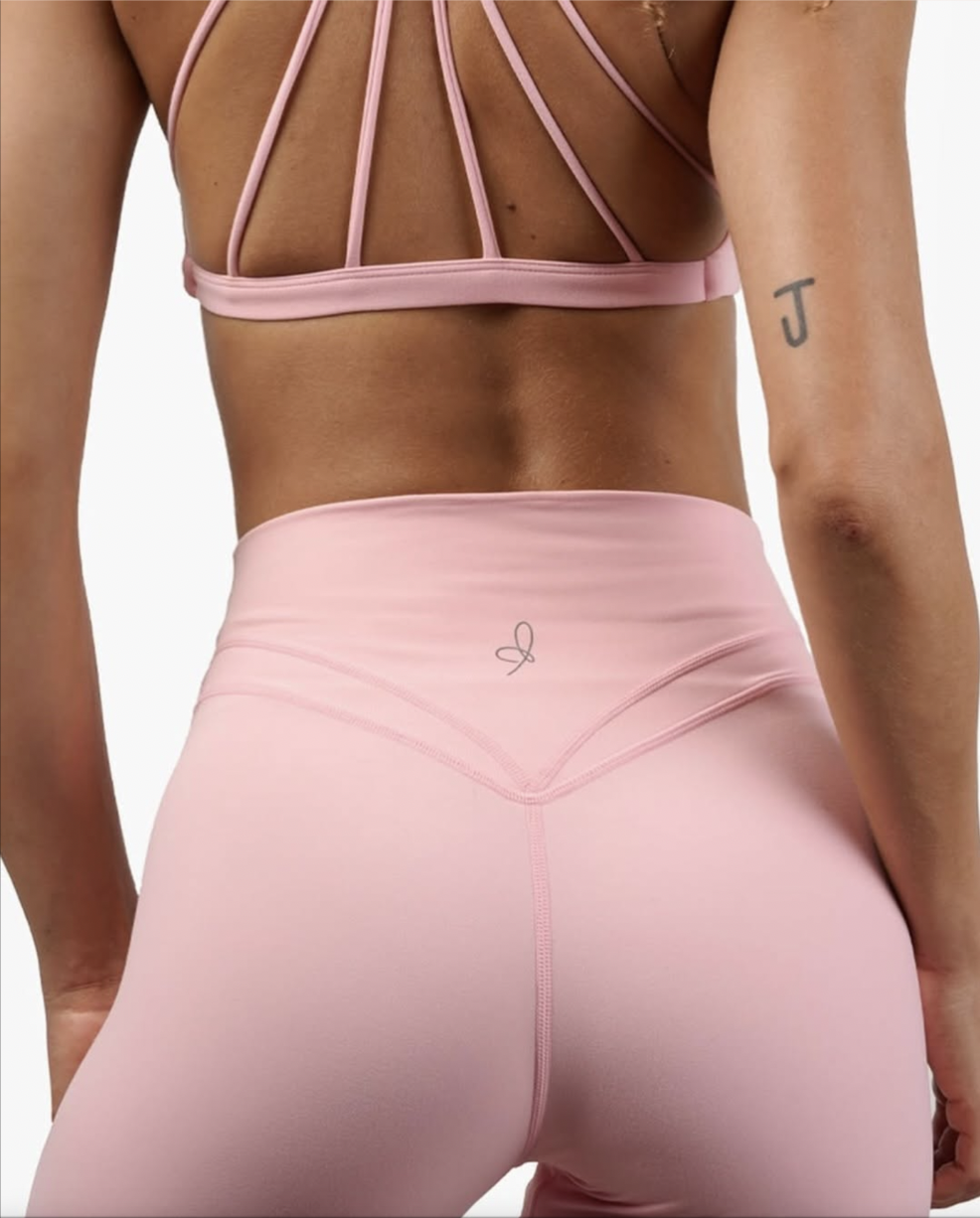 Activewear product detail photography of pink high-rise leggings showing fabric, seams and fit