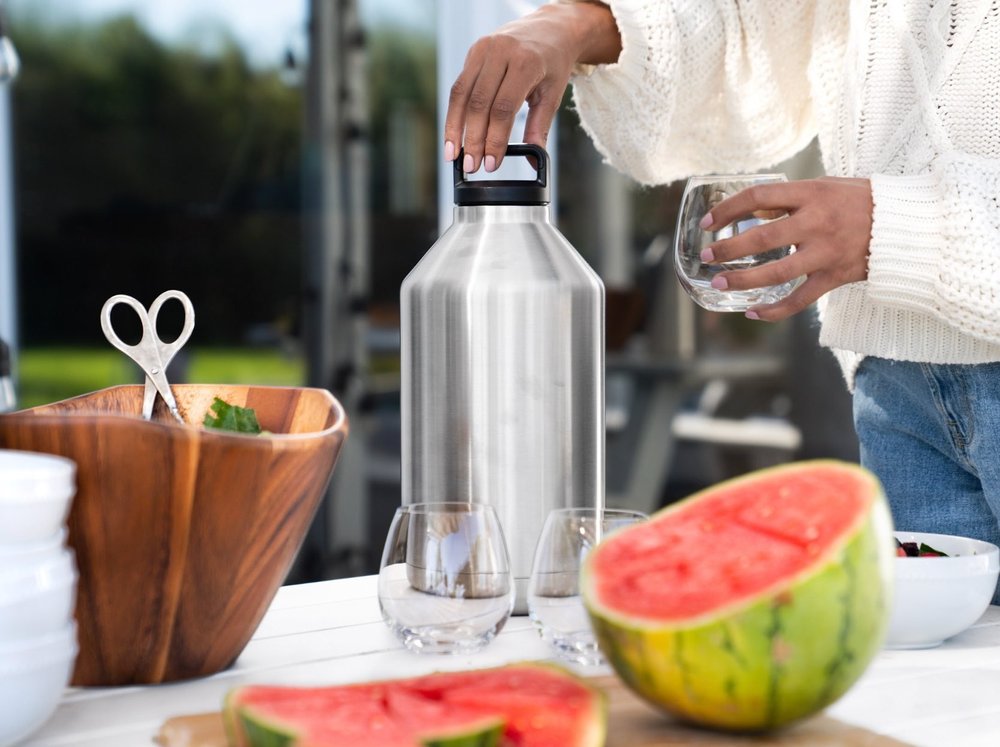 Lifestyle product photography with a hand pouring wine among kitchen and tabletop items, representing a coordinated multi-launch production.