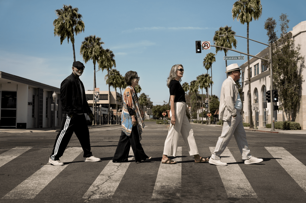 Four older adults crossing a palm-lined San Diego County street for an agency lifestyle campaign, part of the full case study below