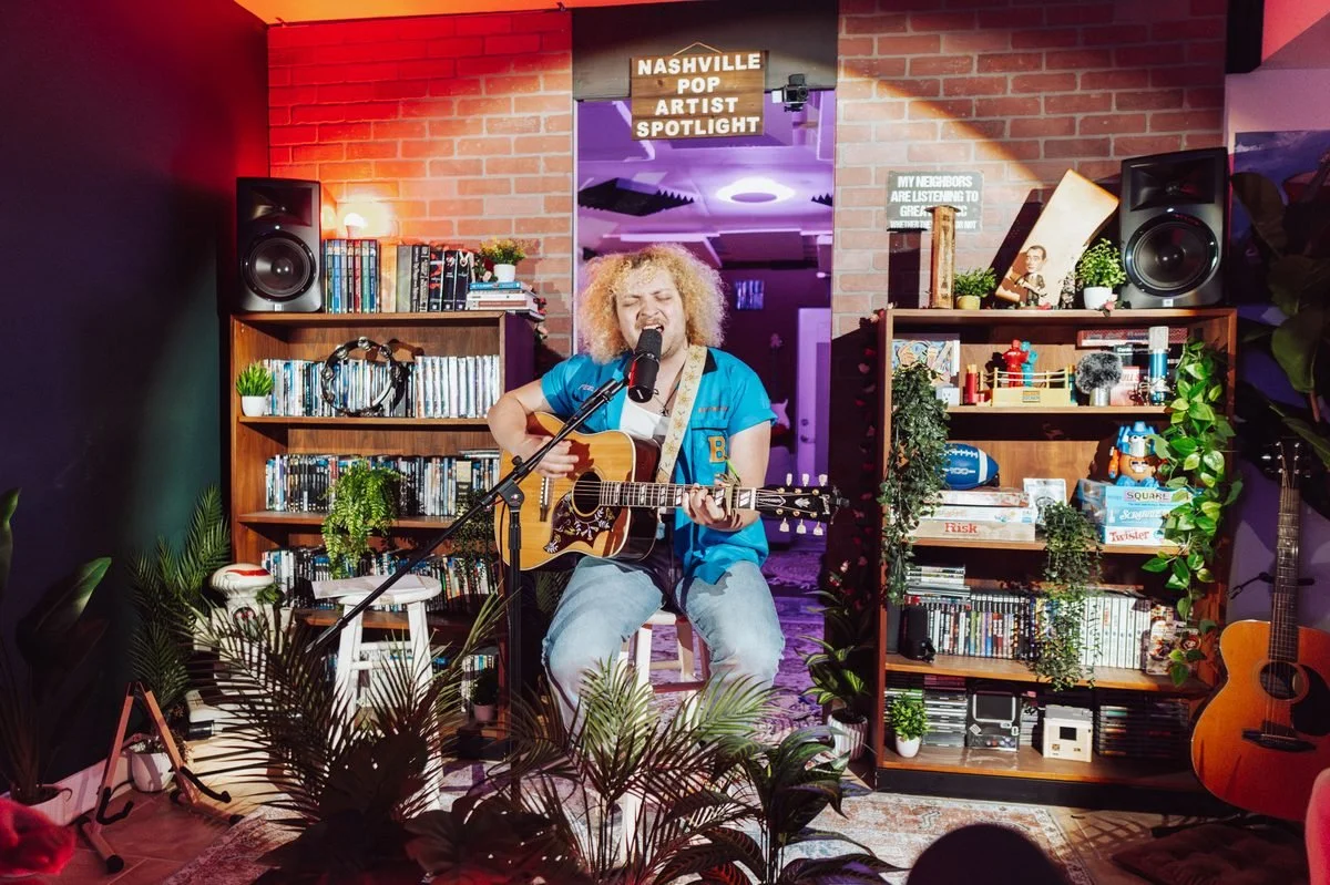 Artist performing live under the Nashville Pop Artist Spotlight sign