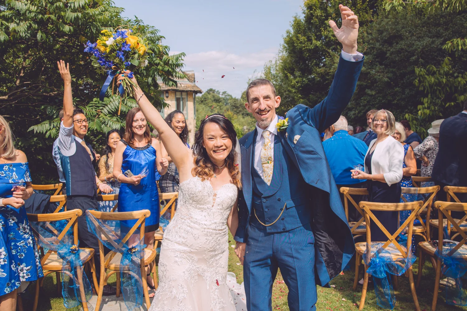 Bride and groom celebrating as guests cheer at The Old Bell, Malmesbury