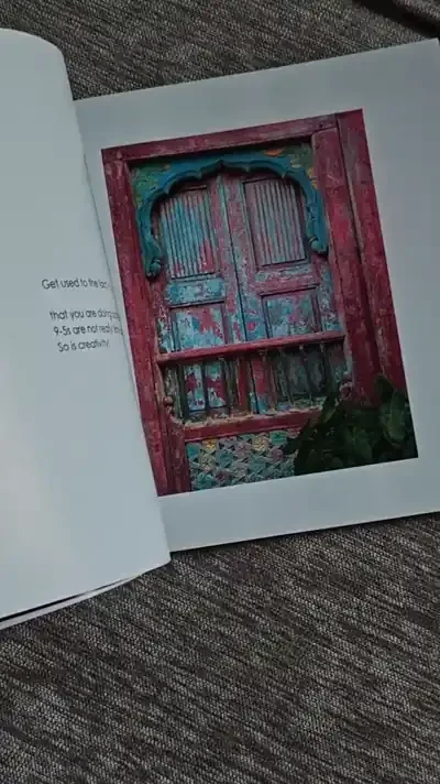 Hands flipping through a printed copy of 9-5 AND ART, ending on the back cover