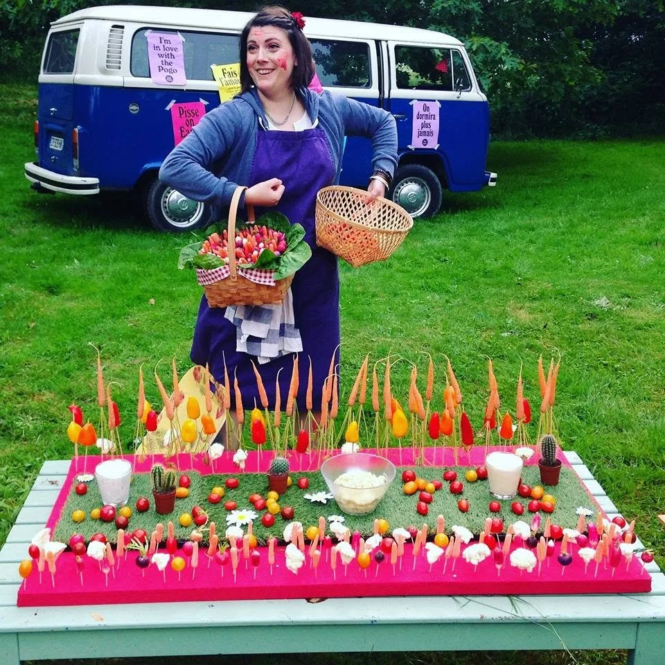 Simone devant son combi et un buffet de crudités