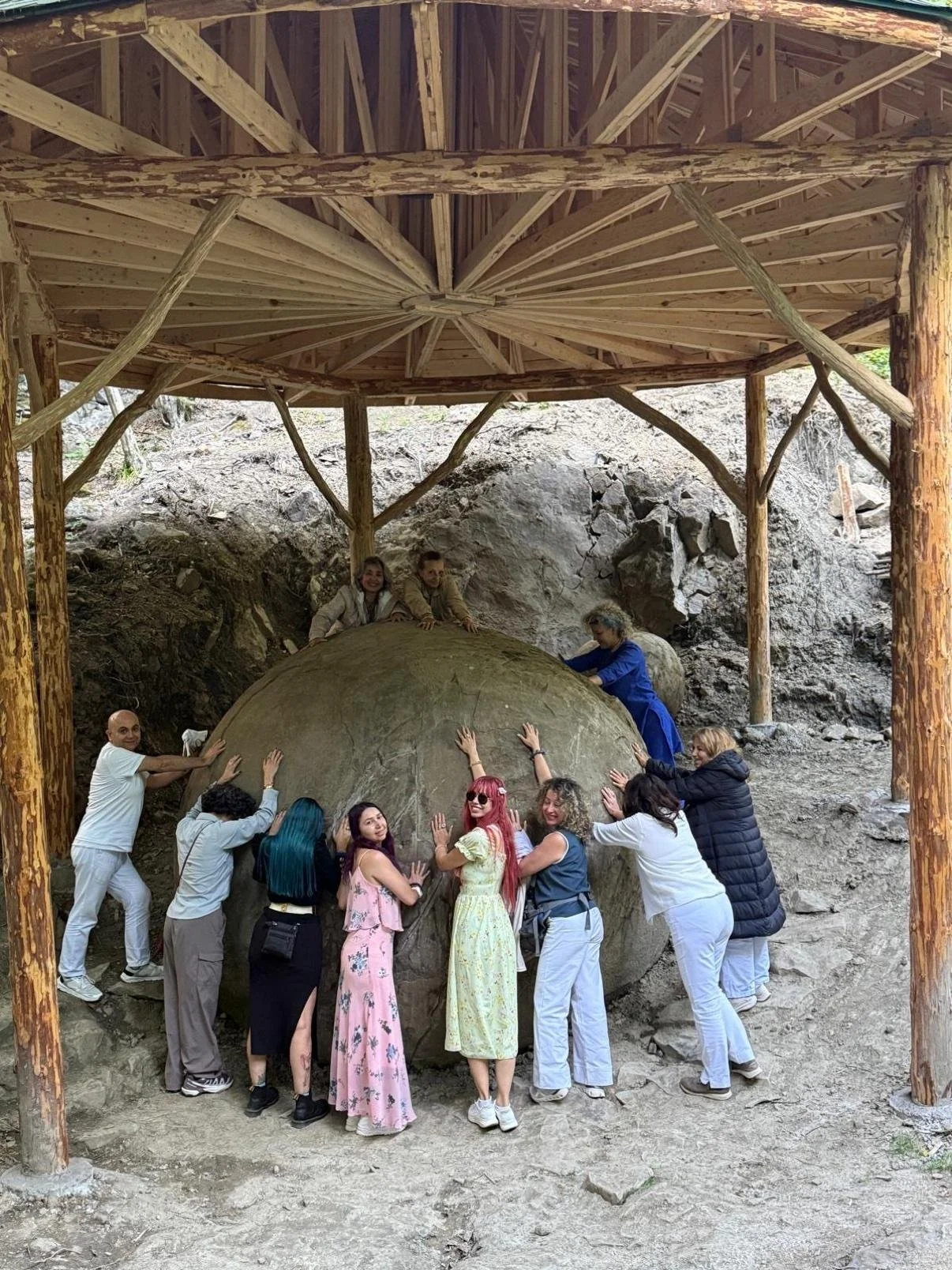 Retreat group gathered around the giant stone sphere