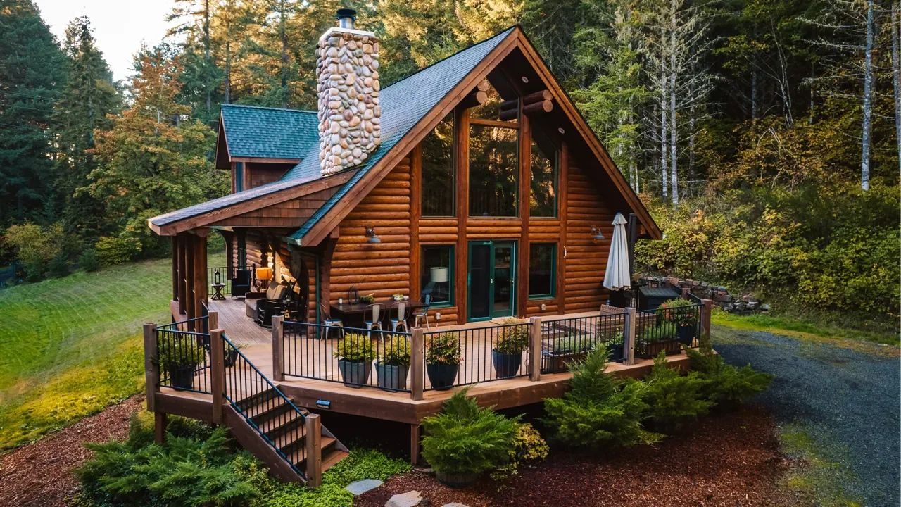 FernLove's log lodge and wraparound deck in the forest at golden hour