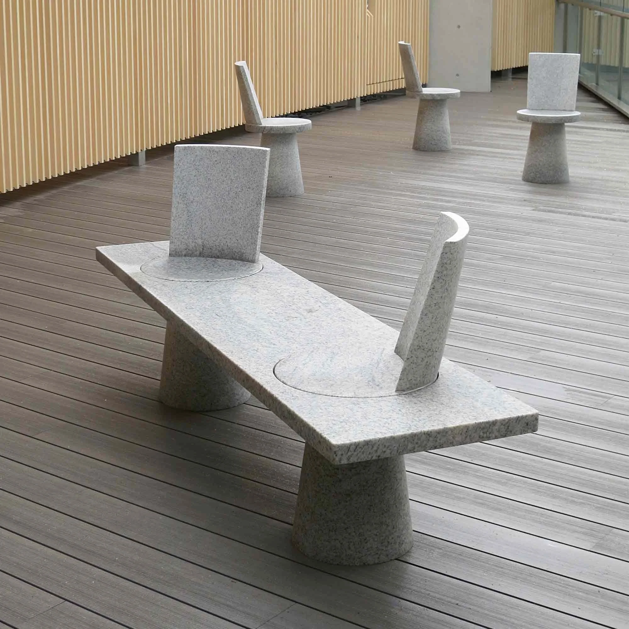 Jasper Morrison's Kamado Shrine Bench, 2012: a granite plank on two tapered drums, with two rotating seats set into it, on the shrine's viewing deck