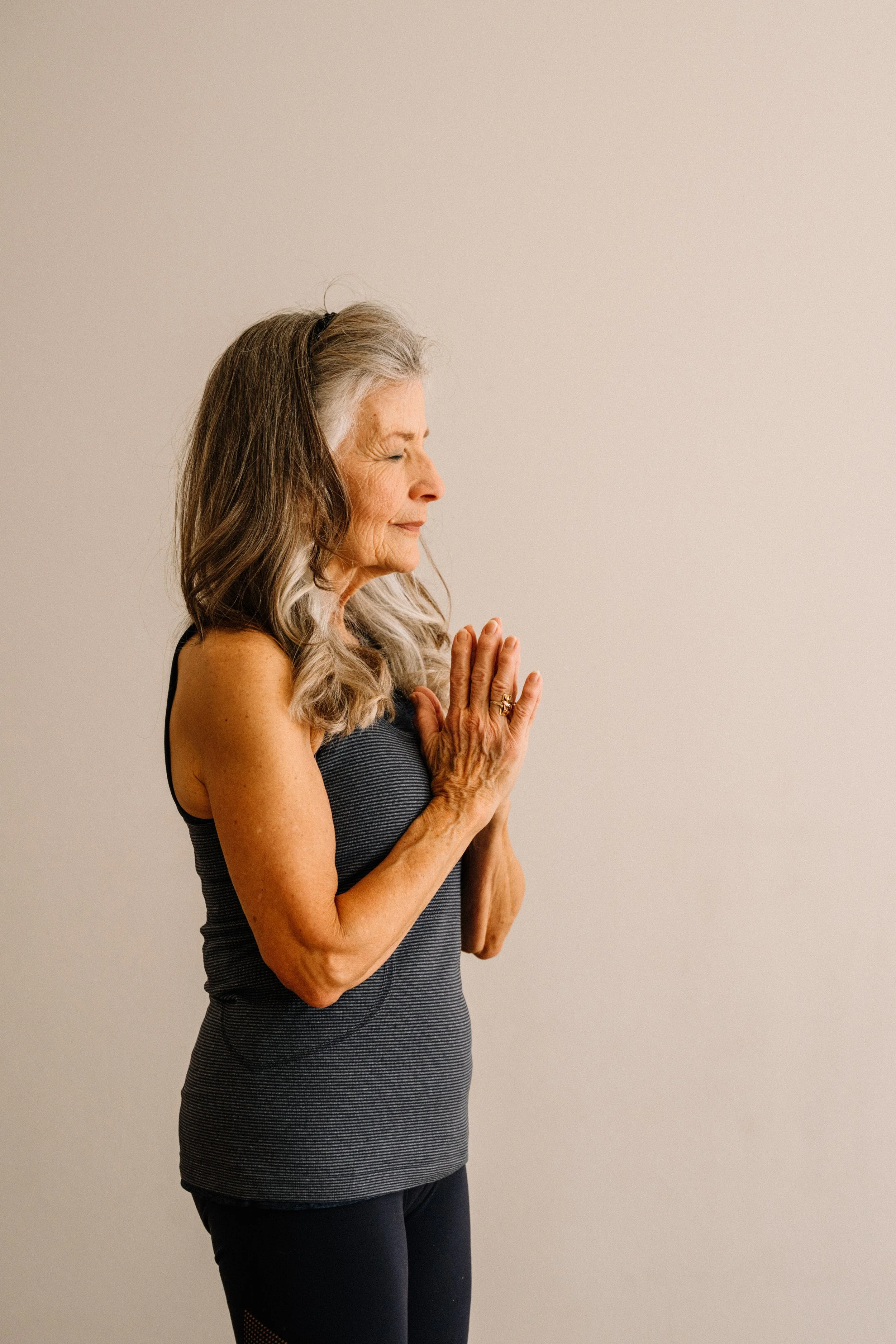 A student standing with hands together at the heart at the end of class