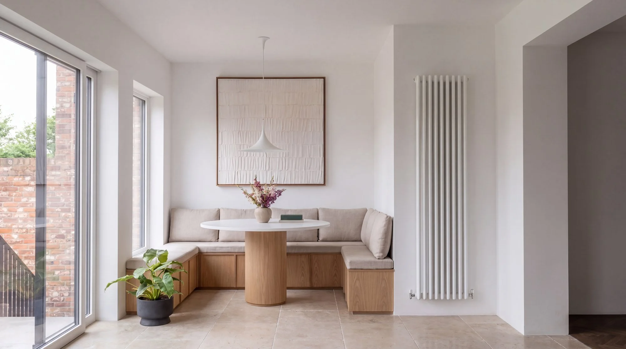 Banquette en chêne et table ronde près des baies