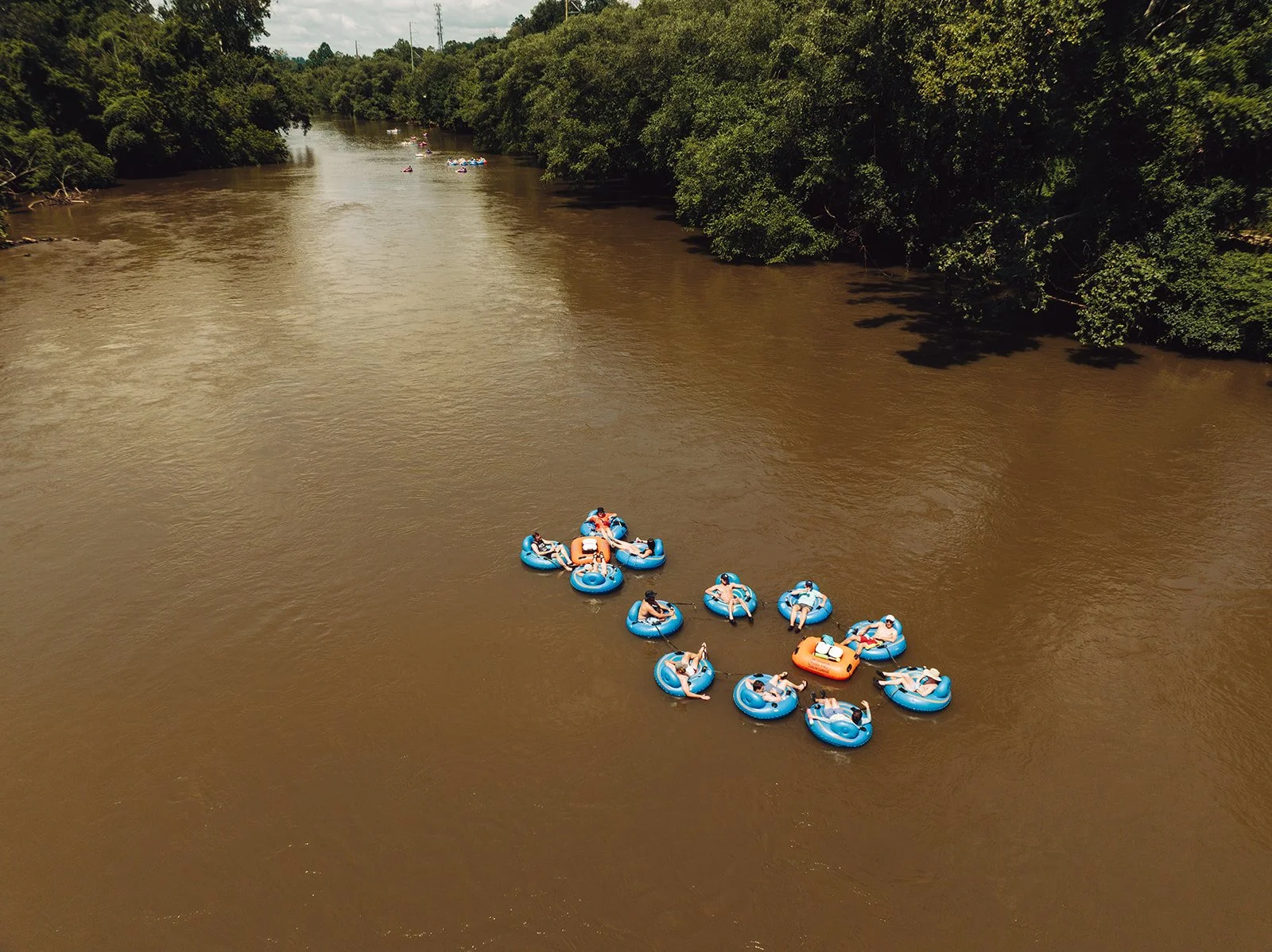 People floating in tubes on the water during an Asheville event activity.