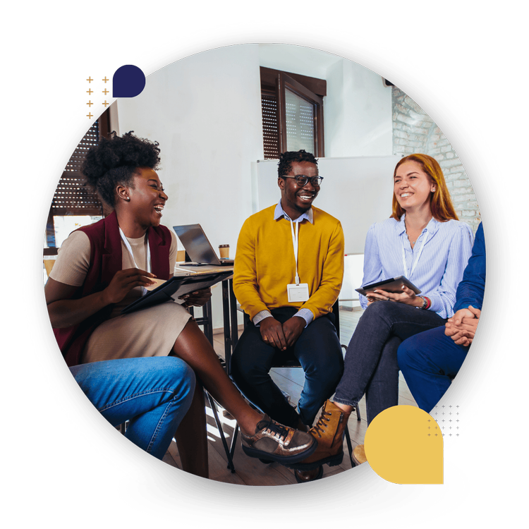 Four diverse people smiling and chatting in a CultureAlly in person workshop.