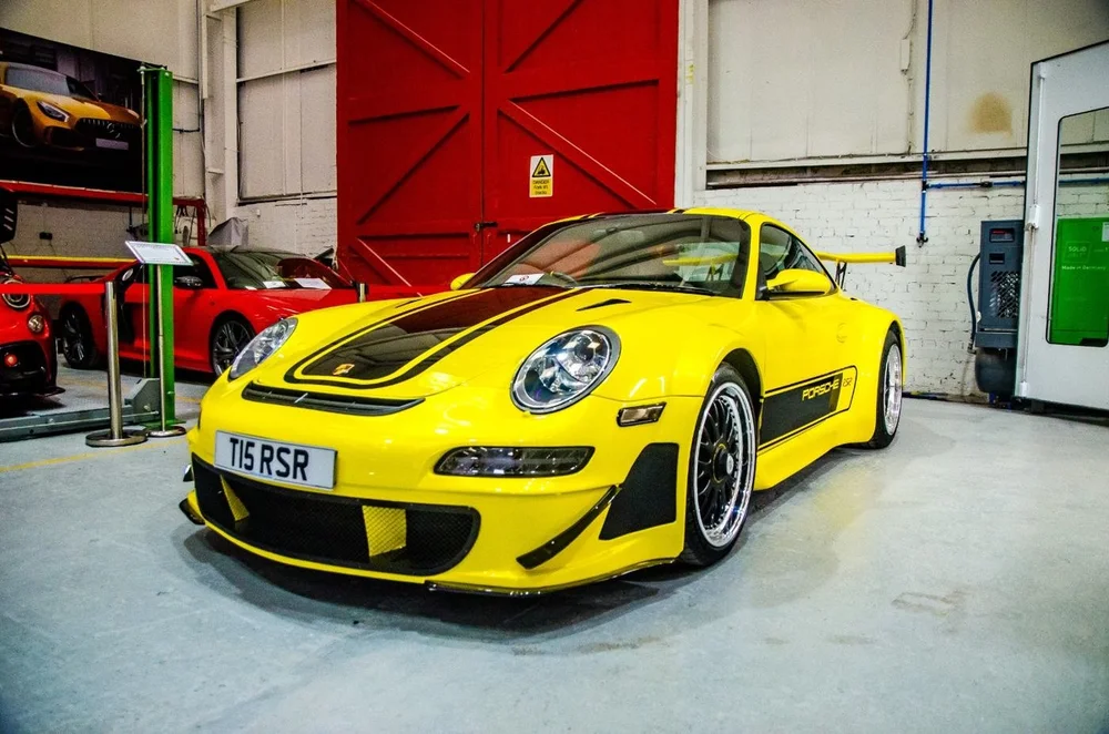 A yellow Porsche 911 inside the workshop