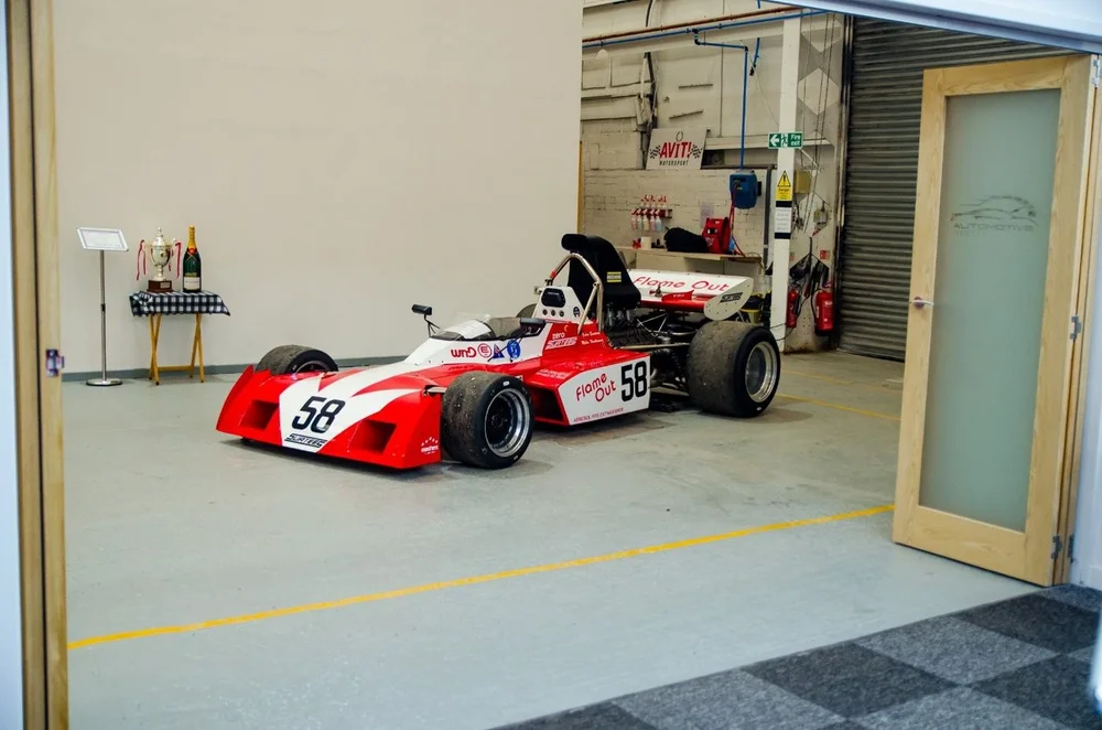A historic single seater race car in the workshop