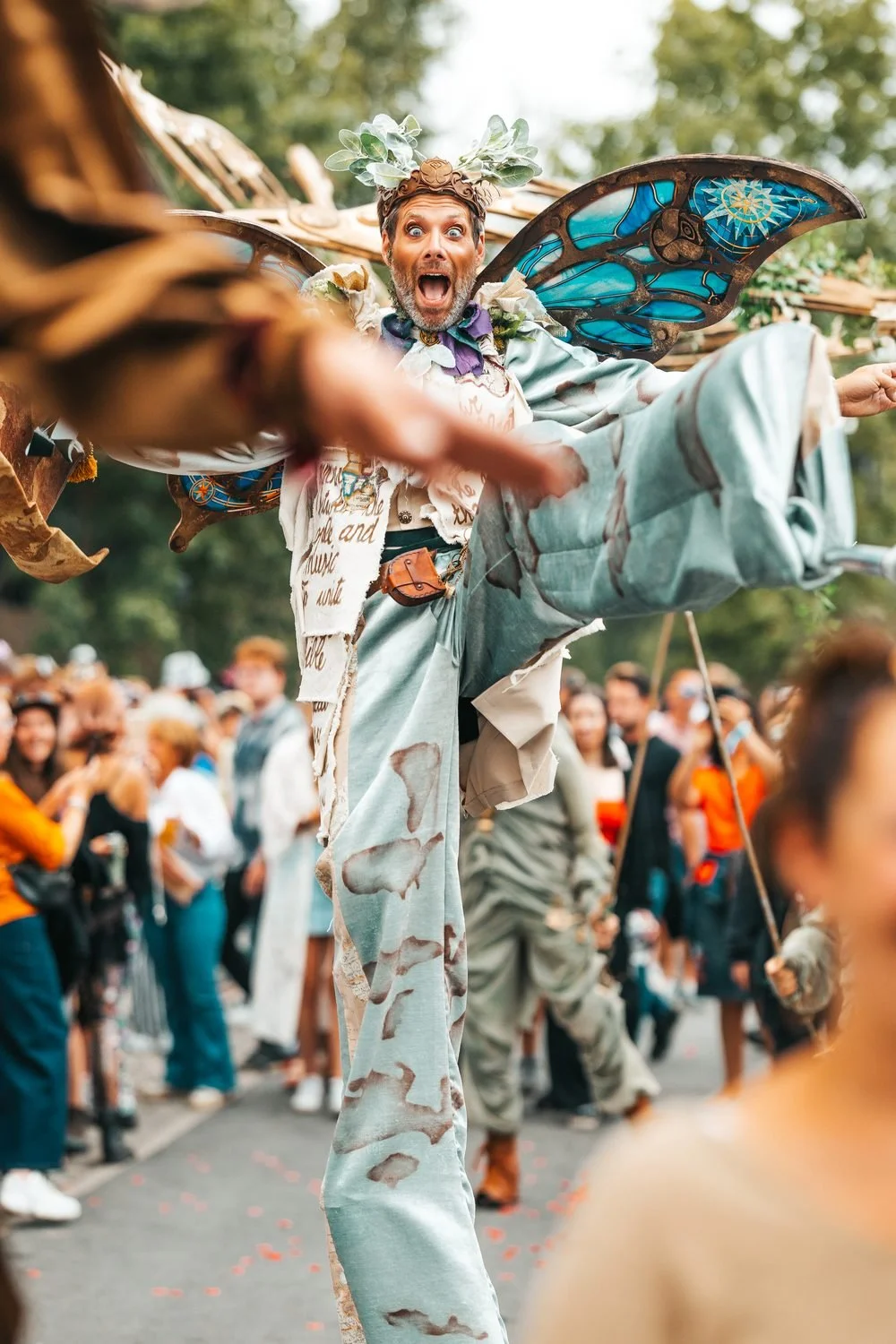 Performer op stelten tussen het festivalpubliek