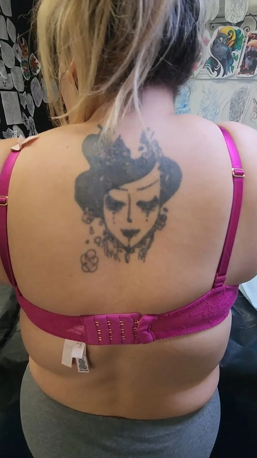 Faded dark geisha face tattoo on upper back before cover-up