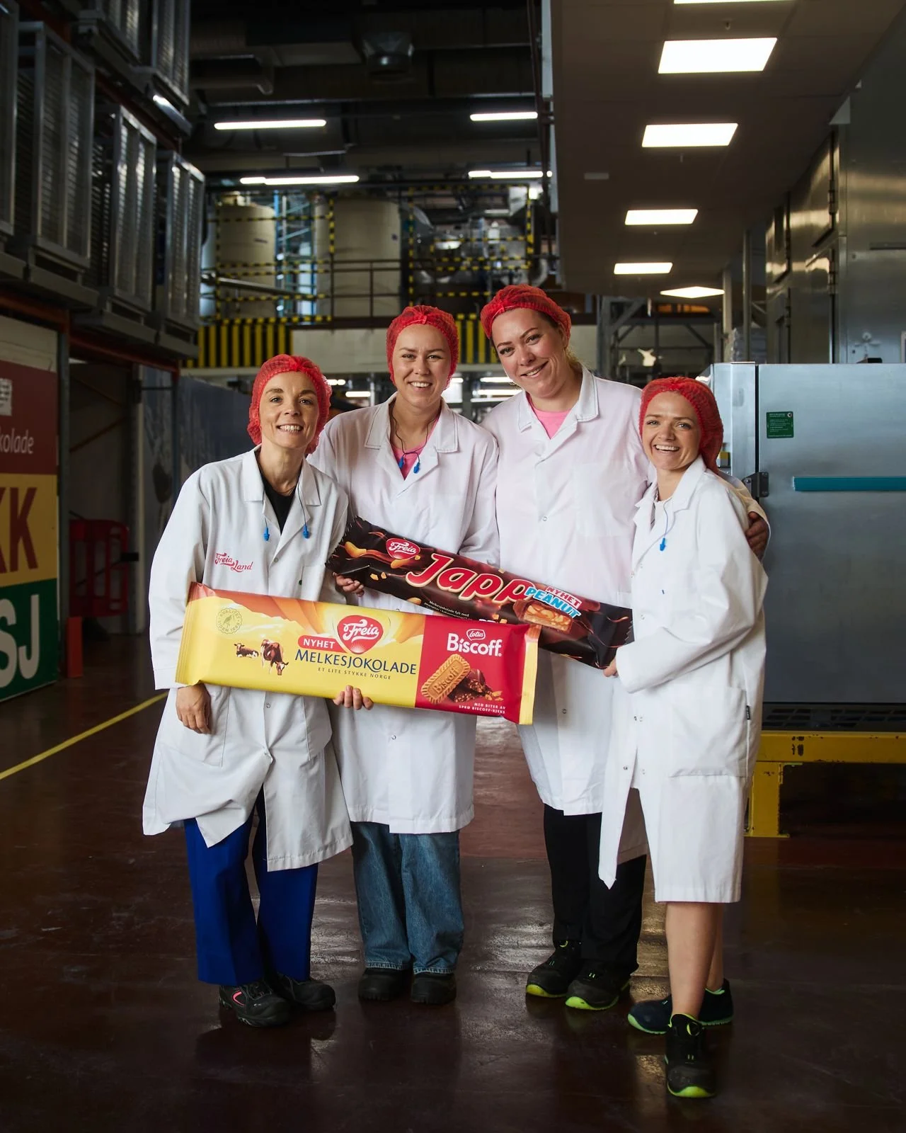 Ansatte på Freia-fabrikken holder gigant-emballasje for Freia Biscoff og Japp Peanut