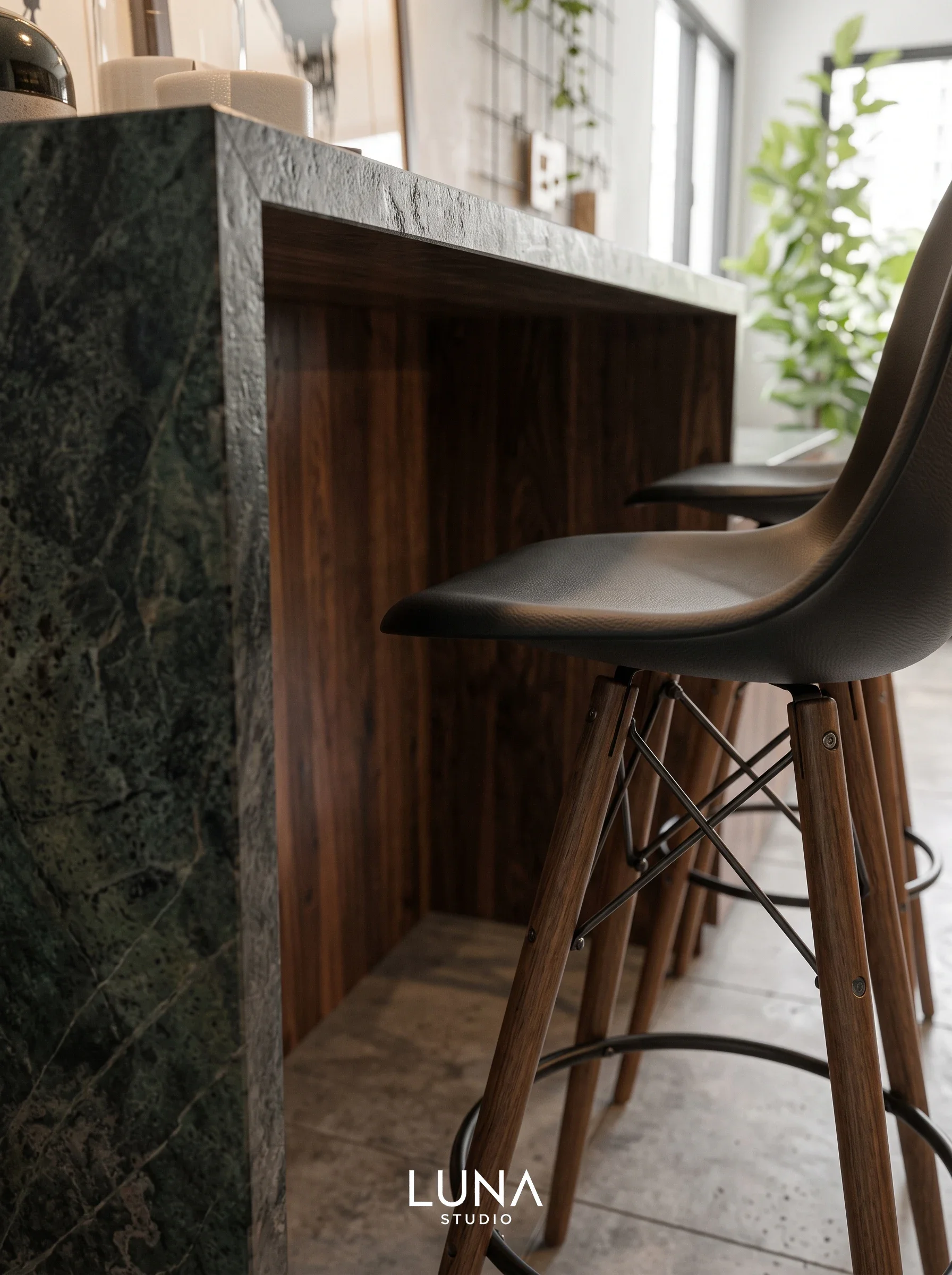 Dark stone kitchen island with timber panelling and leather bar stools.