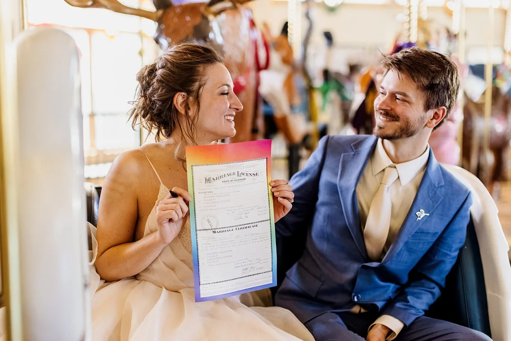 A couple holds up their rainbow marriage license from Broomfield county