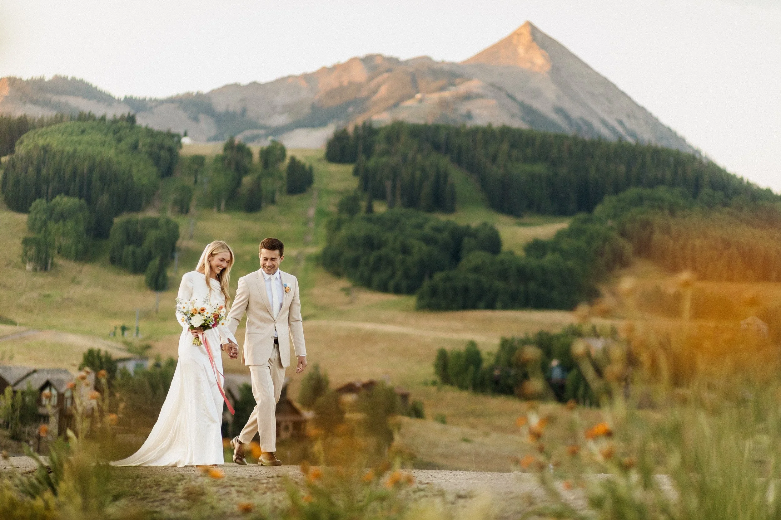 Couple holding hands in a fireweed meadow during their private vow exchange in Crested Butte, Colorado