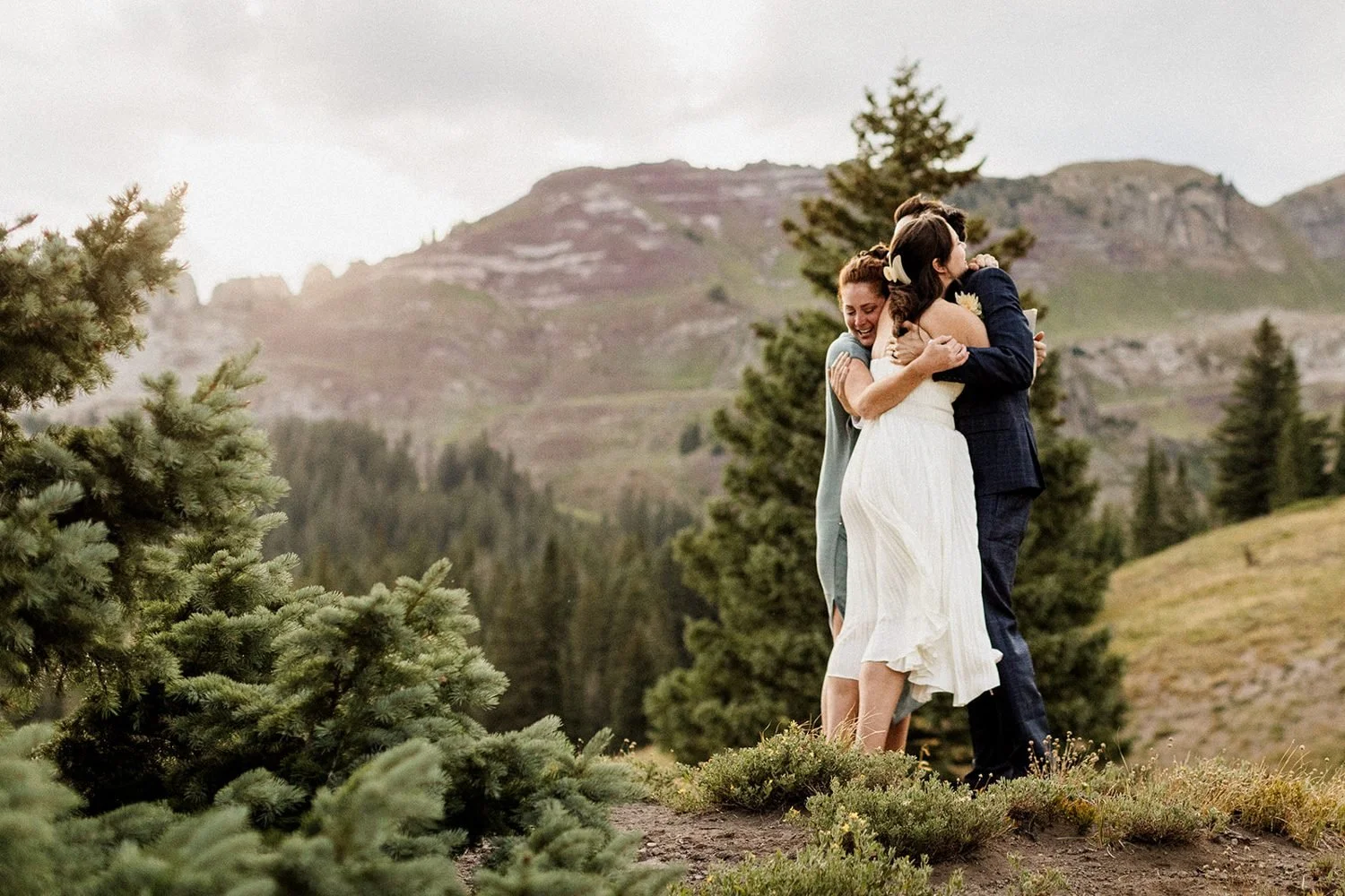 a couple and their officiant embrace after their ceremony