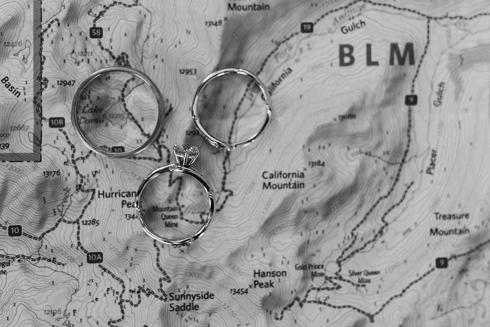 A map spread out with wedding rings on it