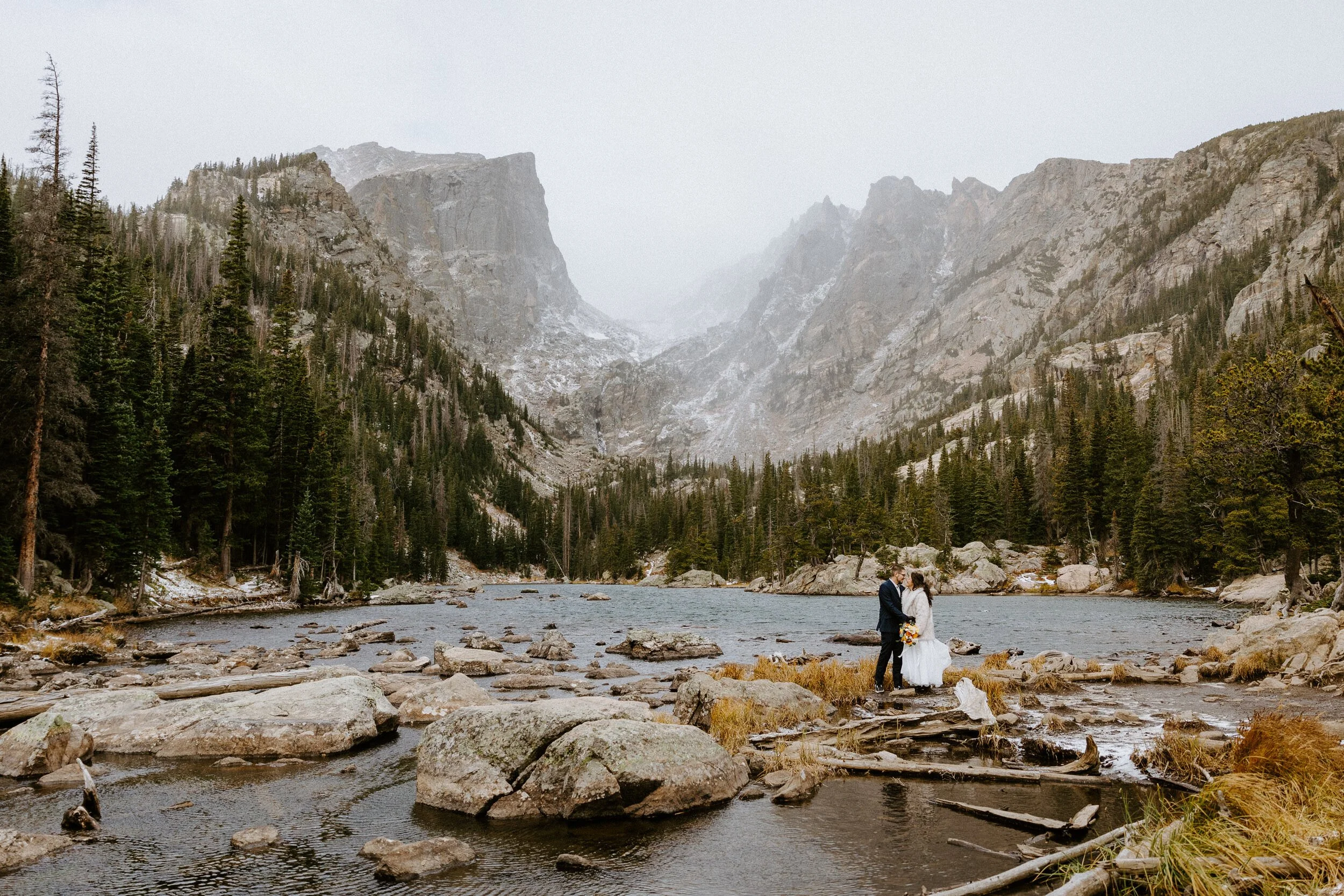Couple at Dream Lake in Rocky Mountain National Park during a snowy October sunrise elopement