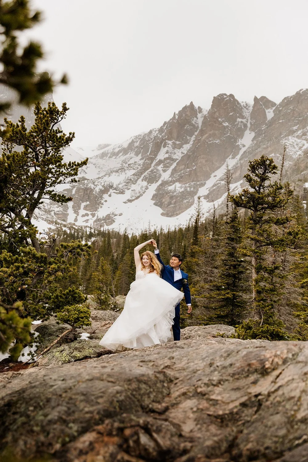A couple twirls in front of Dream Lake at Rocky Mountain National Park after getting married