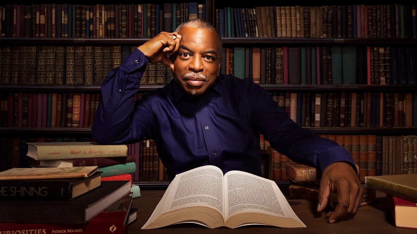 LeVar Burton seated in a library