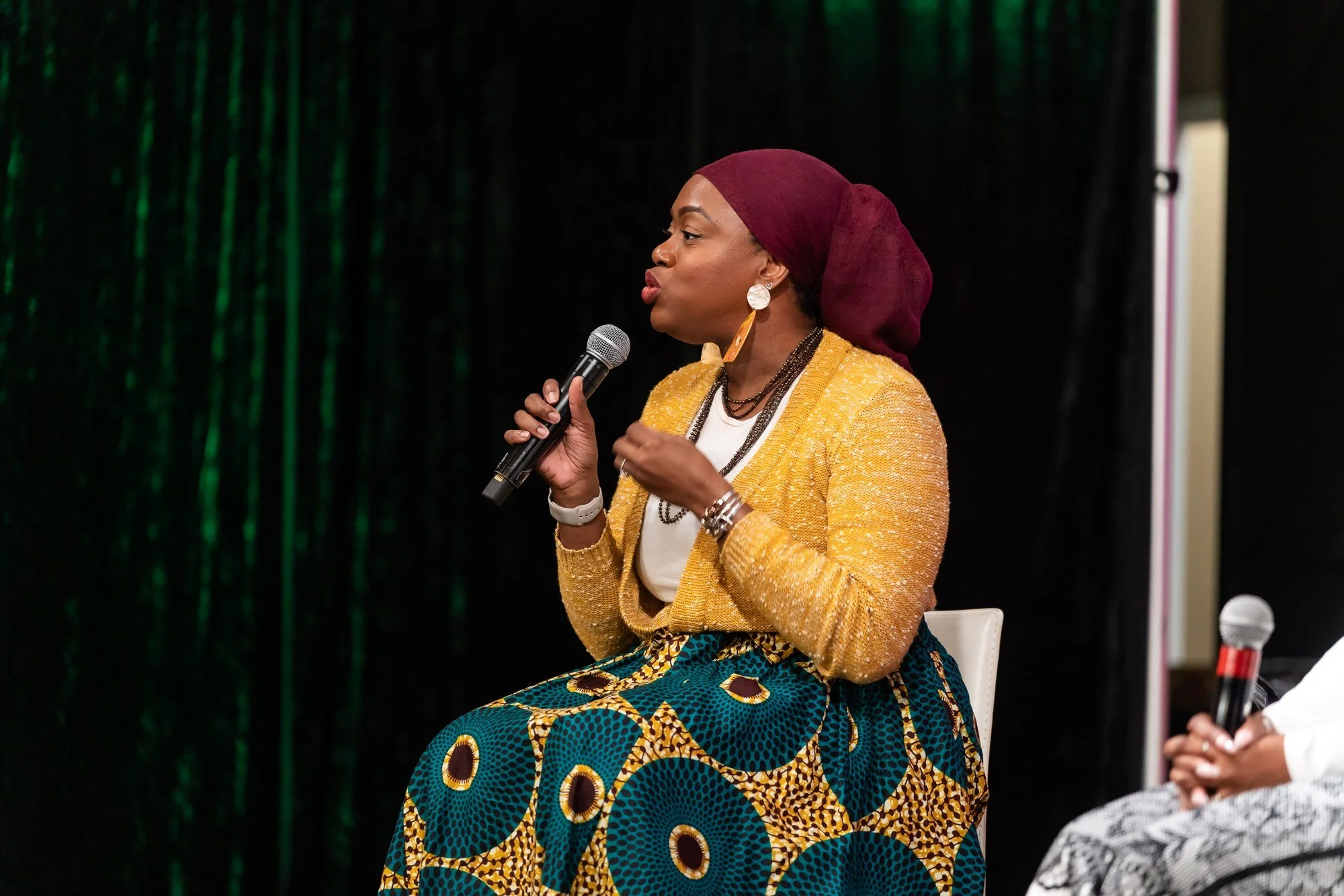 Panelist speaking into a microphone at Baltimore Biz-Con