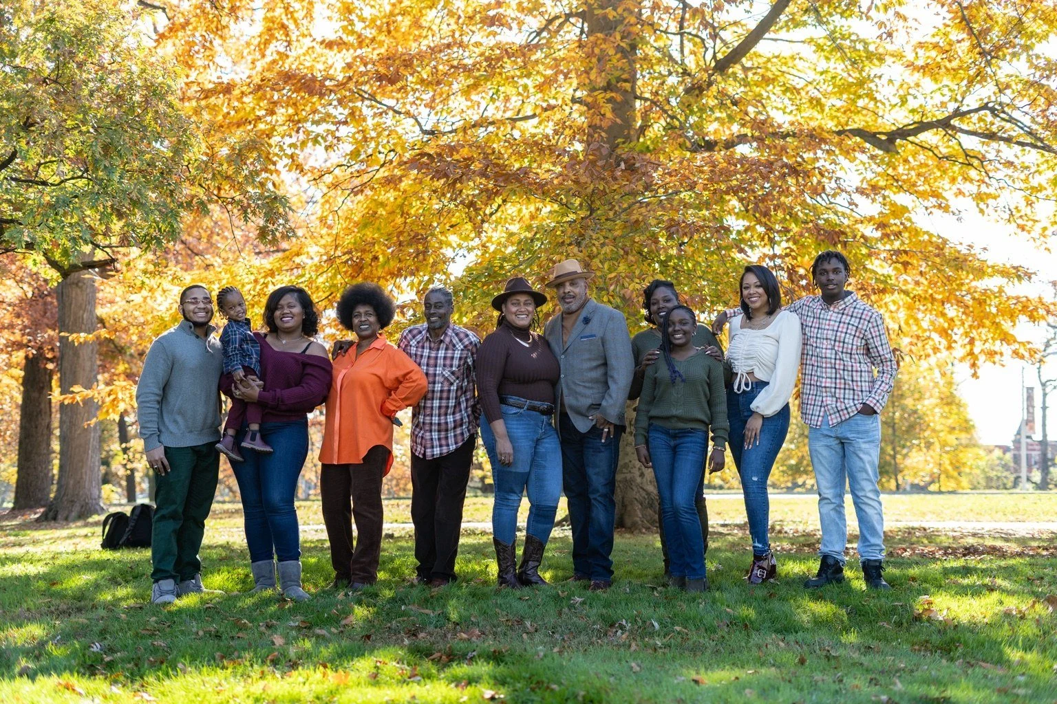 The Wiggins family standing together beneath golden autumn trees