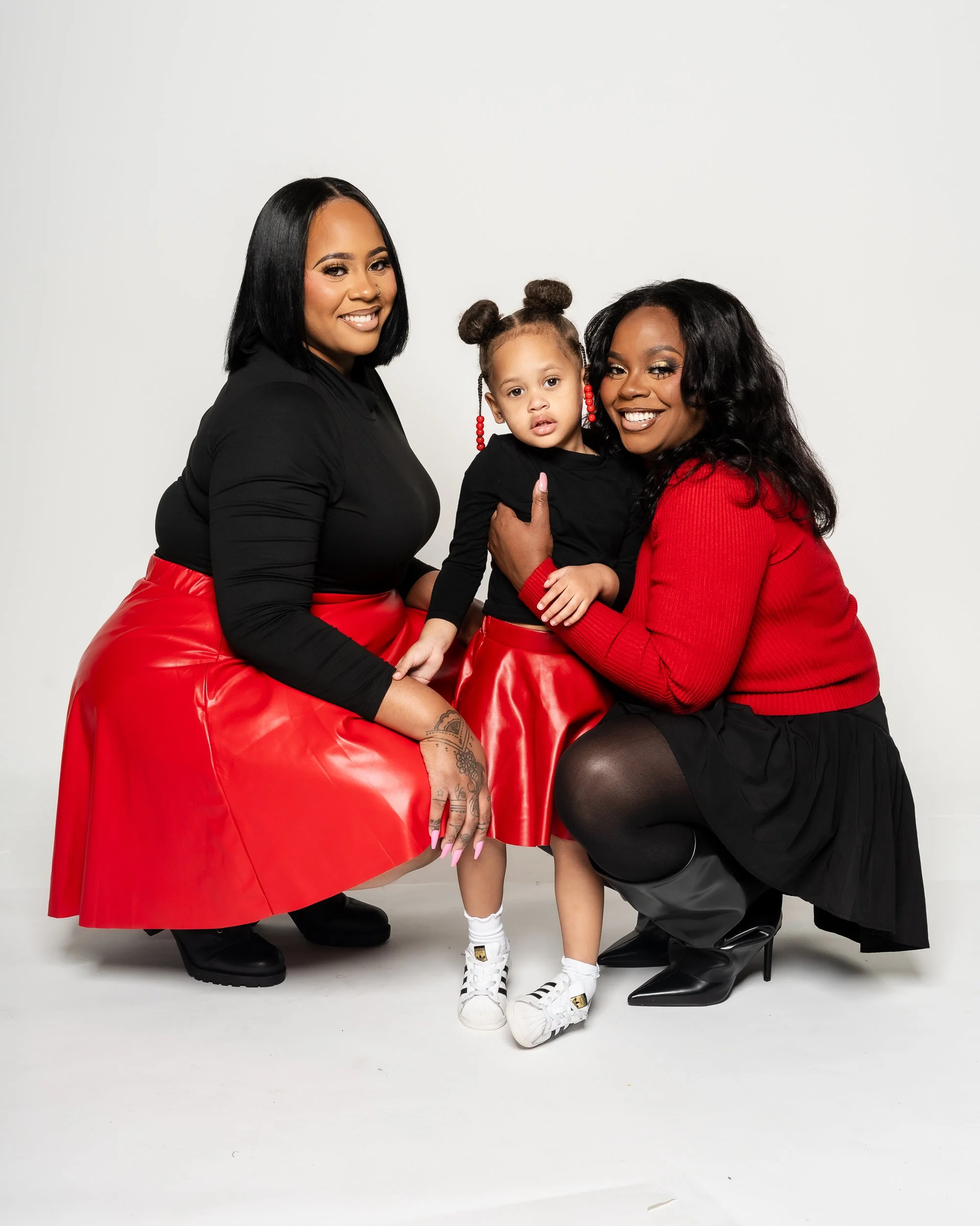 India’s family posing together in coordinated red and black holiday outfits.