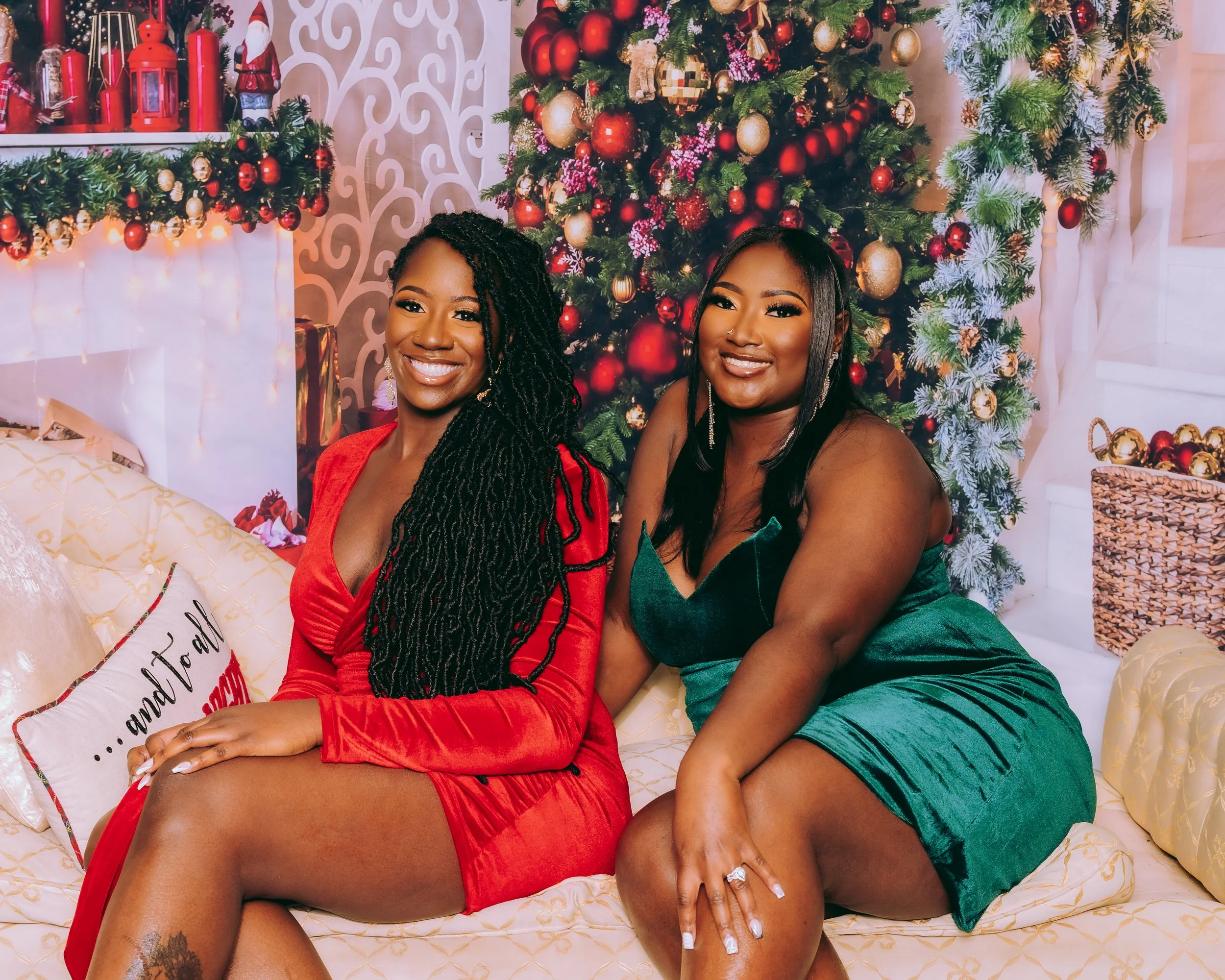 Morai and Nay seated together in festive red and green velvet outfits.