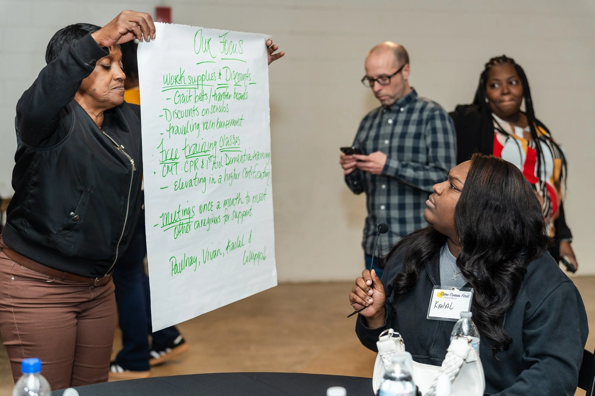Participants sharing a workshop poster during a small-group discussion