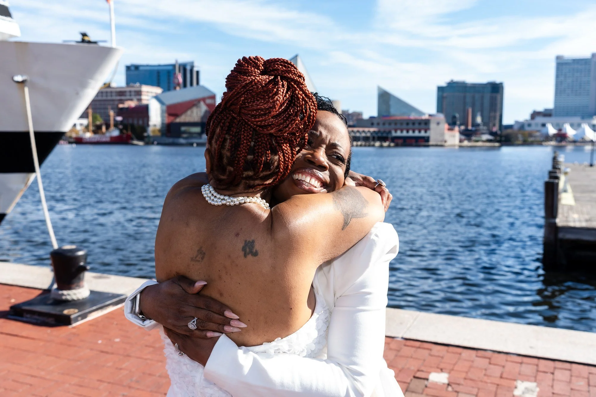 Guests sharing an embrace beside the Baltimore harbor