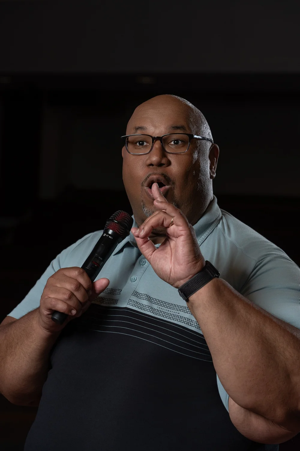 Dr. Michael Dorsey holding a microphone and raising one finger during his branding session