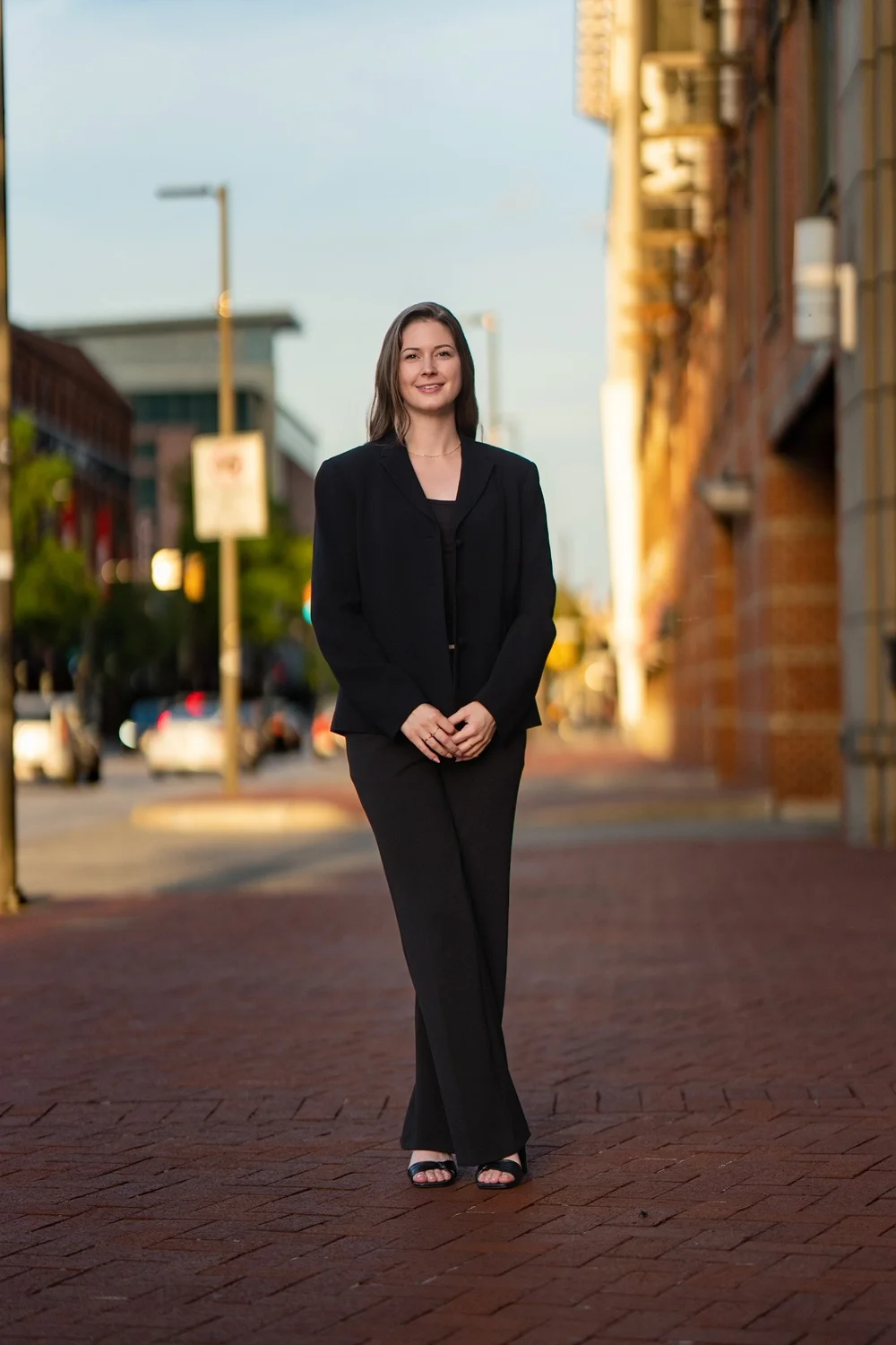 Full-length branding portrait of Sam Rodgers beside Baltimore brick architecture
