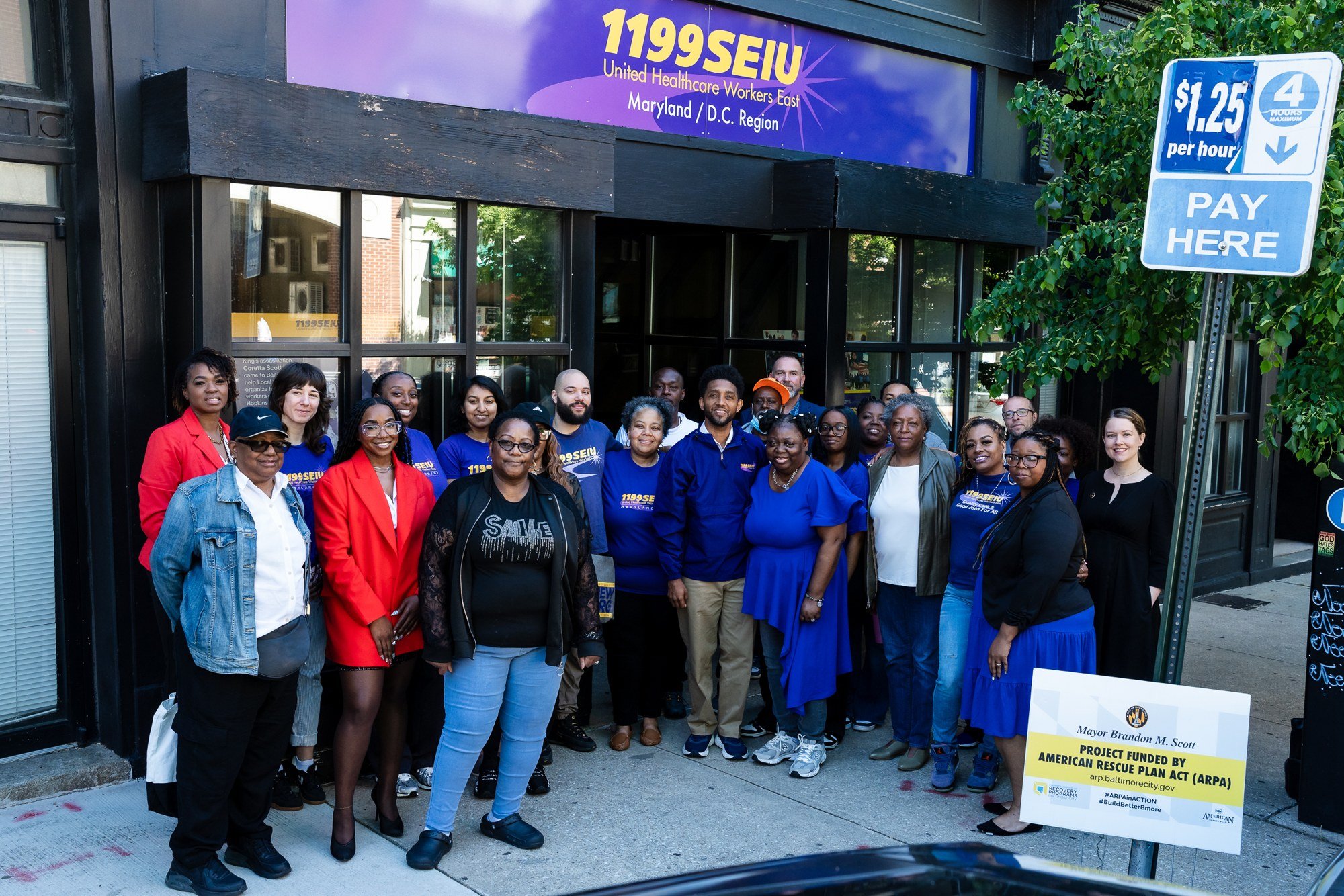 Baltimore City Mayor Brandon Scott with attendees outside the 1199SEIU building after a community event