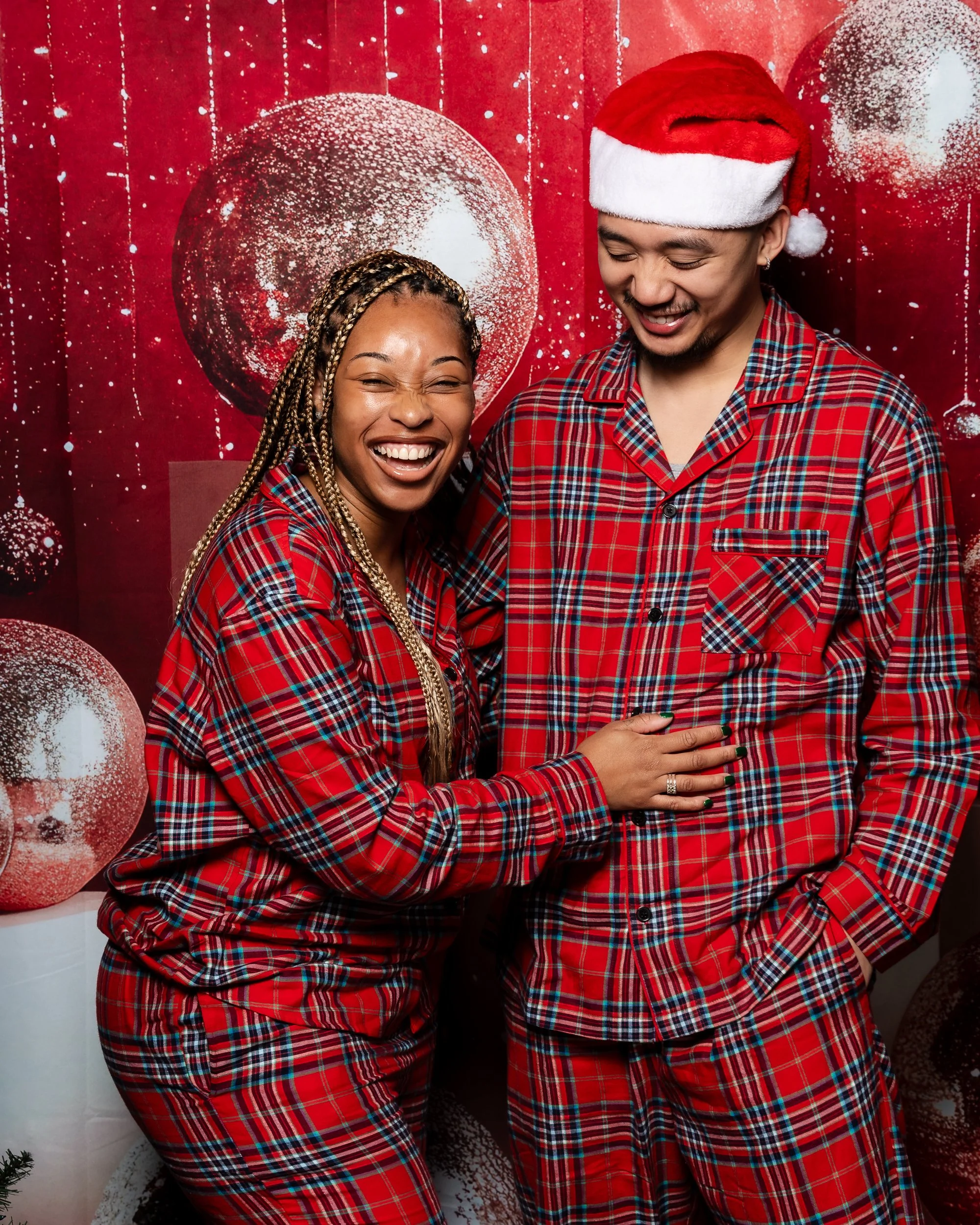 Jill and Nathan laughing together in coordinated red plaid holiday outfits.