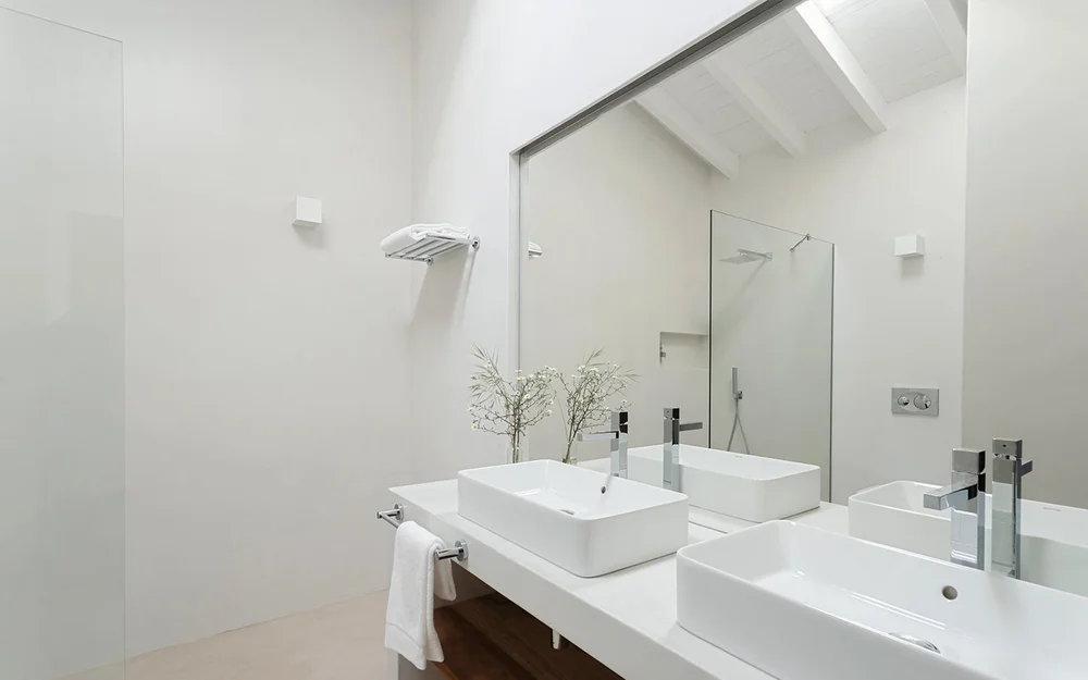 Apartment bathroom with double vanity and glass shower at Amaria