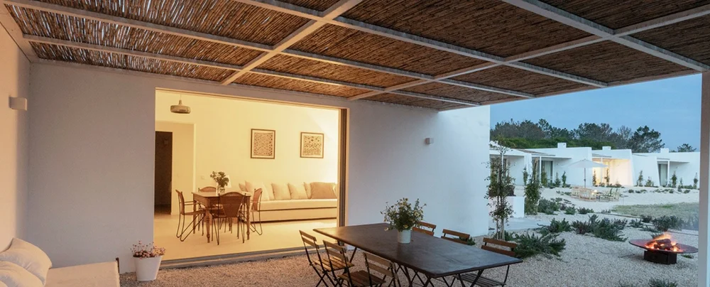 Apartment terrace and glowing living room at blue hour at Amaria