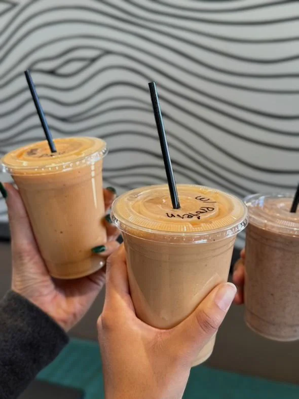 Three Ola smoothies raised in a toast